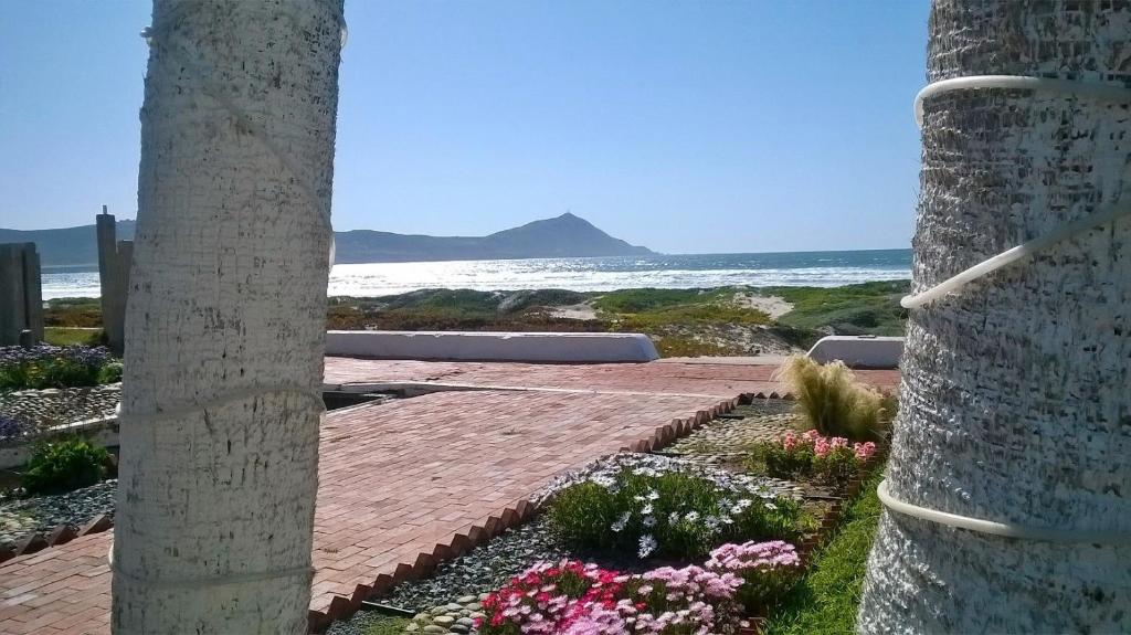 un patio con flores y vistas al océano en Bungalos Las Esperanzas, en Cabo Punta Banda