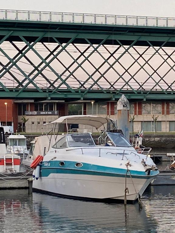 a boat is docked in the water under a bridge at The Happy Sailor in Viana do Castelo