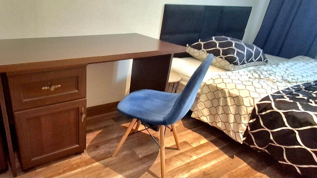 a desk with a blue chair next to a bed at Kielce City Center Old Town Rynek 4 bedrooms in Kielce