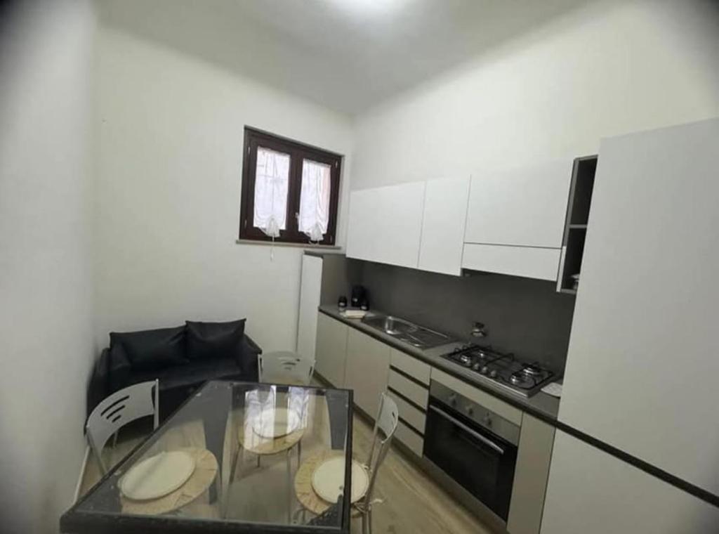 eine kleine Küche mit einem Glastisch und einem Herd in der Unterkunft Appartamento due passi dal mare in Grottammare