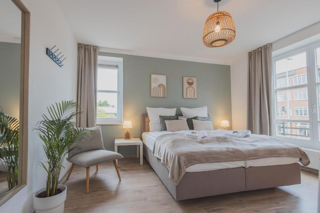 a bedroom with a large bed and a chair at Rentaflat Hamburg 01 am Bahnhof in Norderstedt