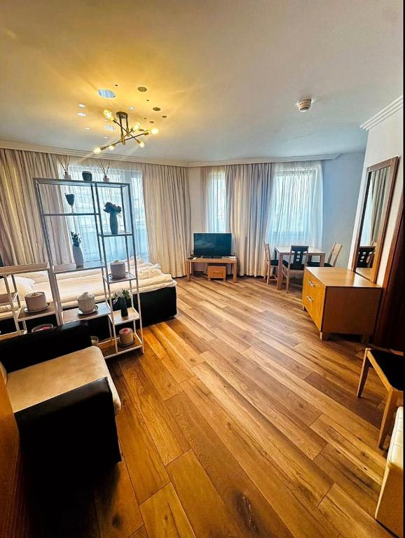 a large living room with a large wooden floor at Emerald Breeze Studio in Hotel SPA Resort Emerald in Ravda