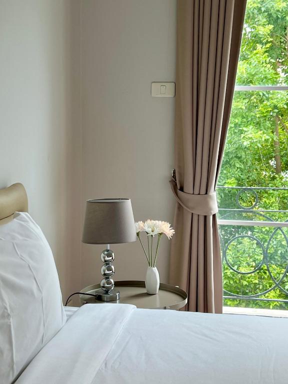 a bedroom with a bed and a table with a window at Entire 3BR Townhome in Sukhumvit, shared Pool, near BTS&MRT Asok in Bangkok