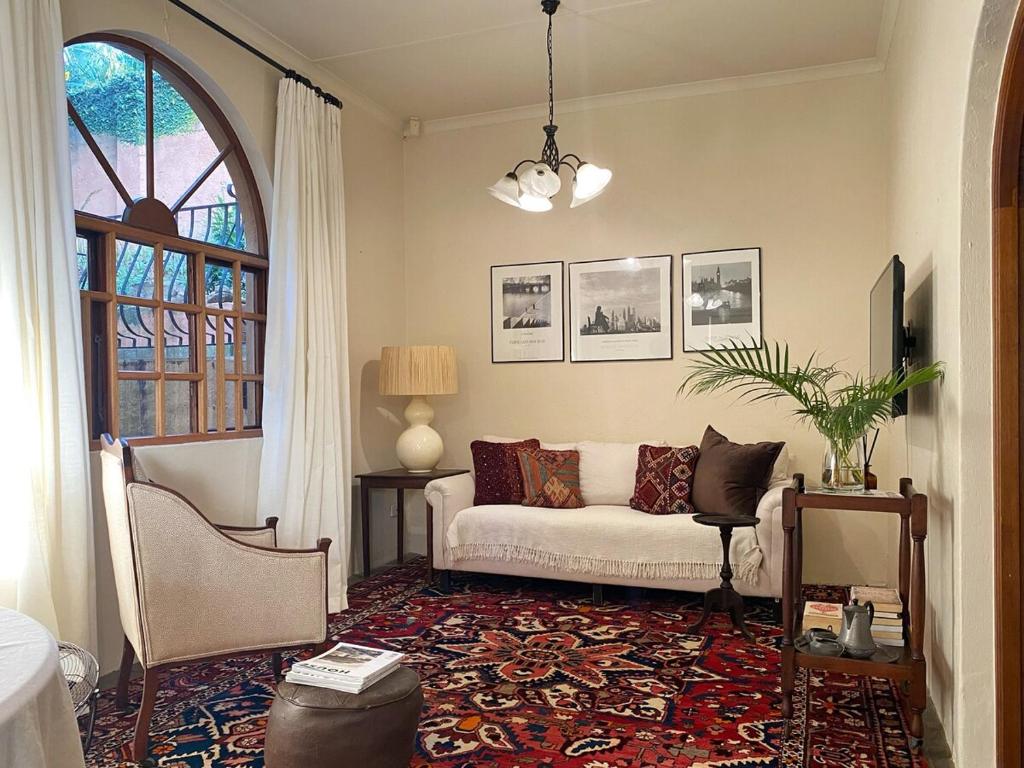 a living room with a white couch and a window at Casa Miramare - Marina Beach in Southbroom