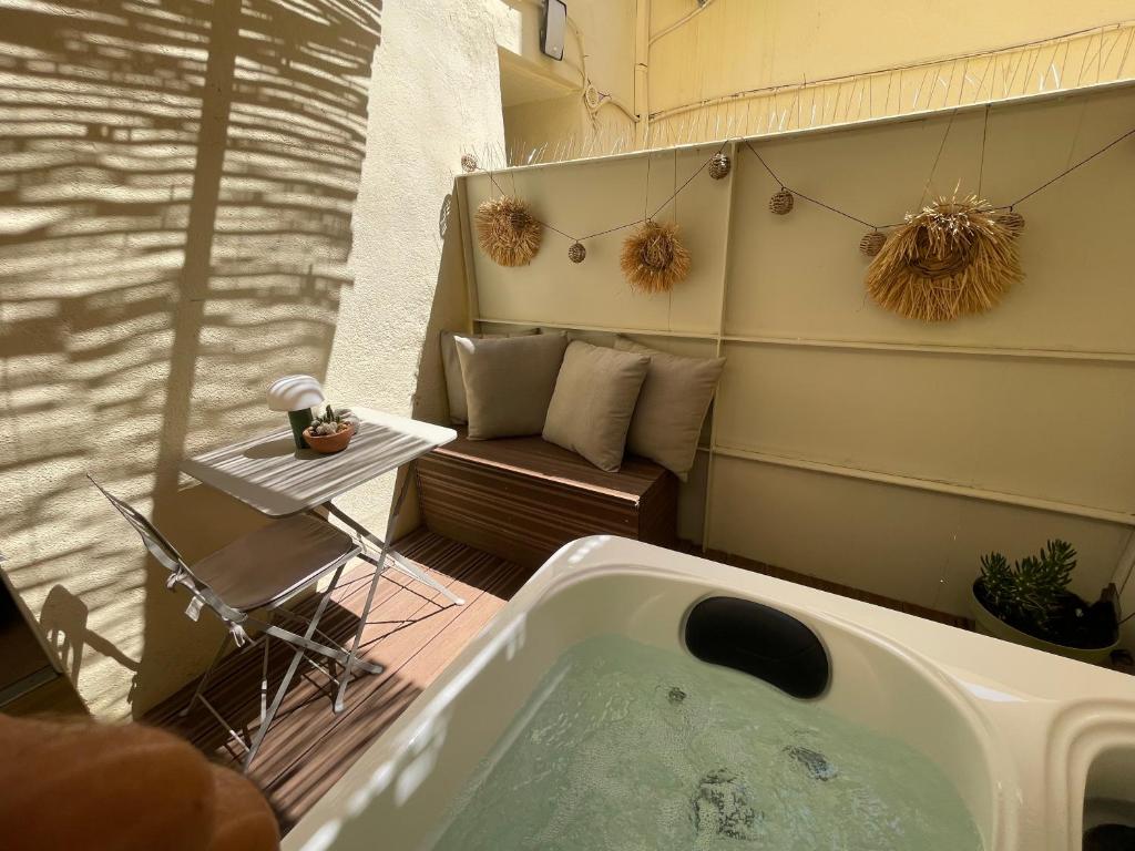 a bath tub sitting on a balcony with a couch at Appartement Ceyreste La Ciotat - jacuzzi in Ceyreste