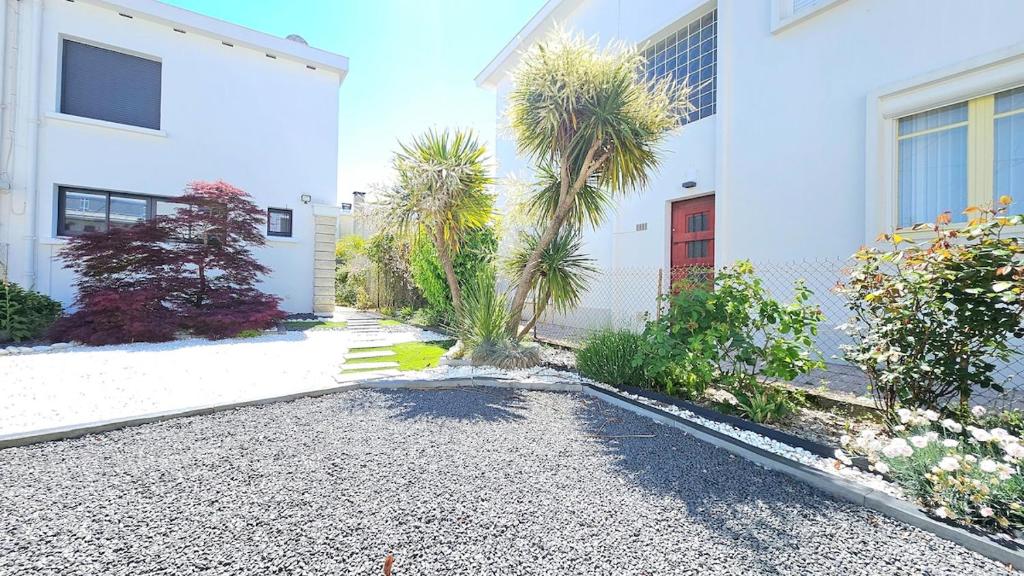 a house with palm trees and a gravel driveway at 3star 1950s house, 3 bedrooms, 6 people, walk to beach center in Royan