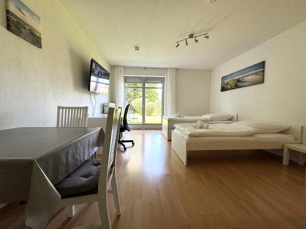 a room with two beds and a table in it at WuP Living Apartment am Stadtwald TG Parkplatz in Augsburg