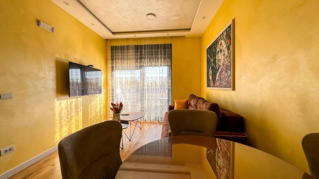 a living room with yellow walls and a table and chairs at Harmony Apartment 2 in Bar