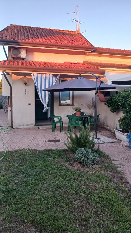 una mesa de picnic verde frente a una casa en Plumbago, en Torre del Lago Puccini