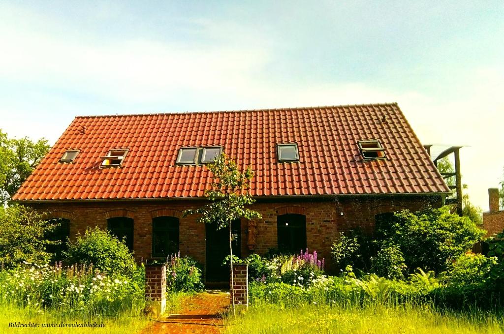a brick house with an orange roof at Der Eulenblick - Seminarhaus, Ferienhaus, Gästehaus, Reitstation, Am Waldrand in Tewswoos