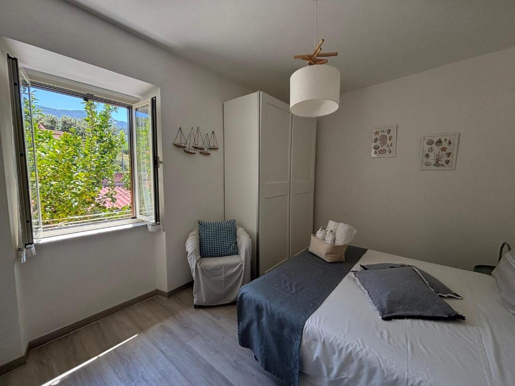 a bedroom with a bed and a window and a chair at Appartamento La Fontina in Marciana Marina