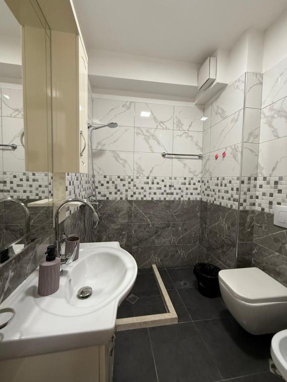 a bathroom with a sink and a toilet at Bejart Apartment 7 in Tirana