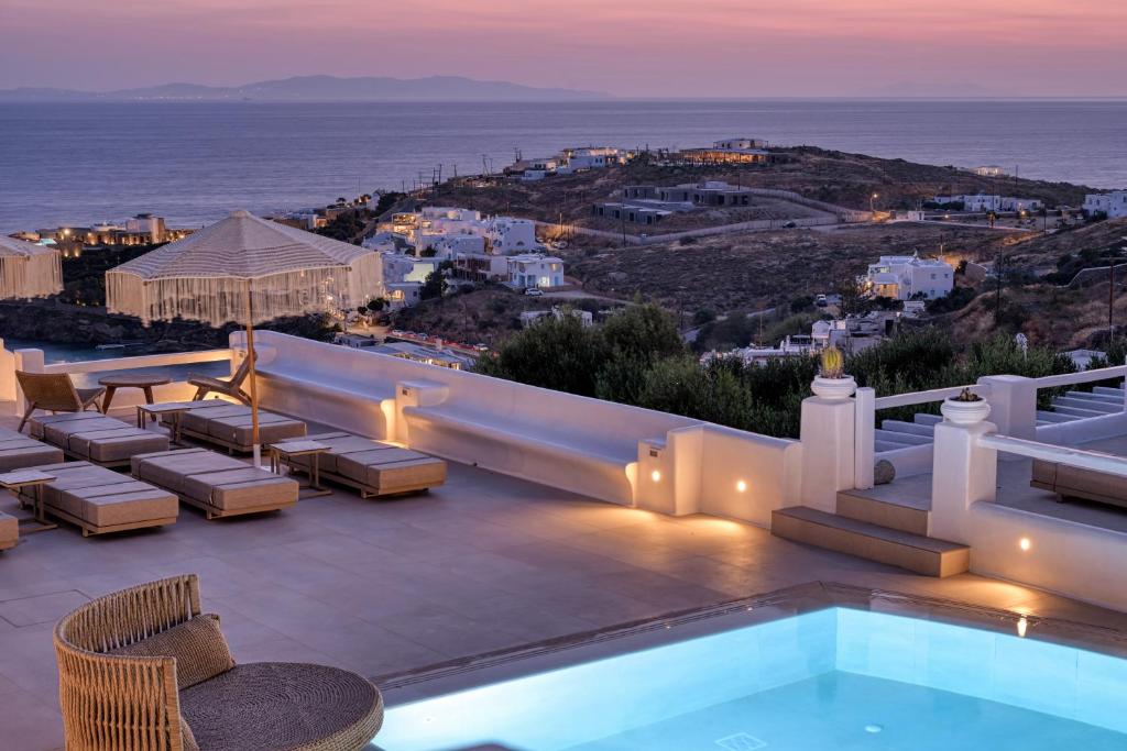eine Villa mit Swimmingpool und Blick auf das Meer in der Unterkunft Paolas Sunset in Agios Stefanos