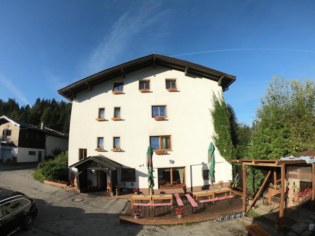a large white building with a black roof at Pension Tyrol Maria Alm in Maria Alm am Steinernen Meer