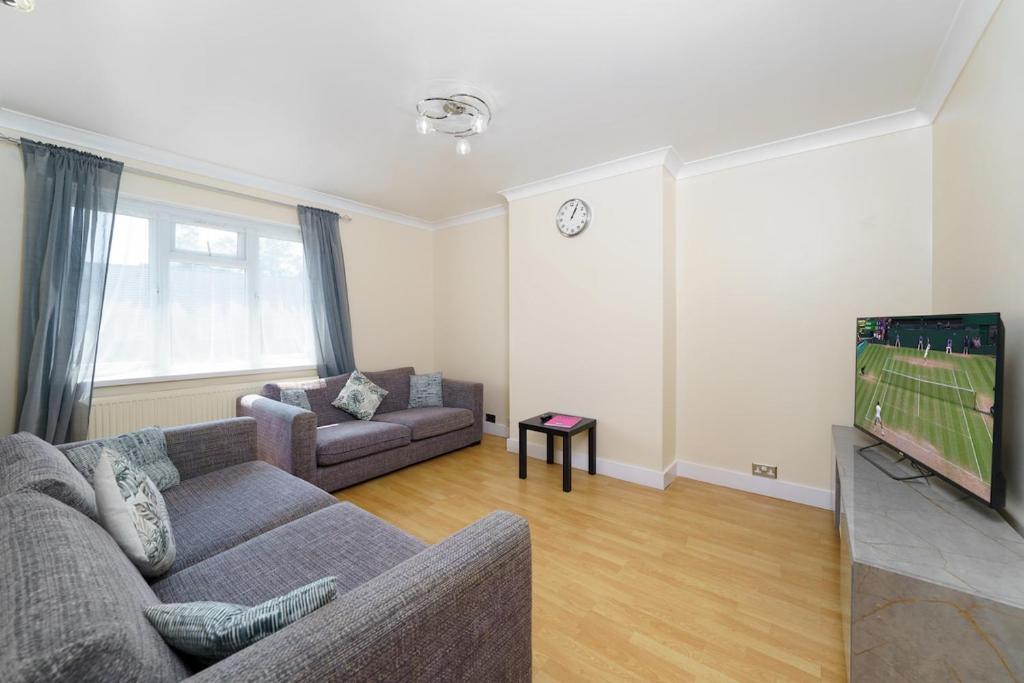 a living room with a couch and a tv at 2BR Apartment near Heathrow Airport in Harmondsworth