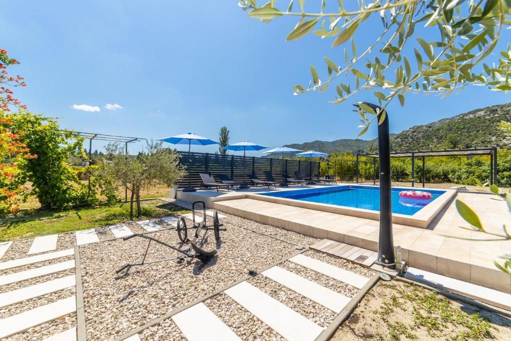 a villa with a swimming pool with mountains in the background at Villa Zorka in Staševica
