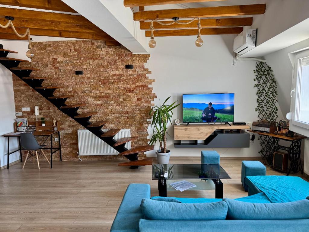 a living room with blue furniture and a brick wall at Gallery City Center Apartment in Skopje