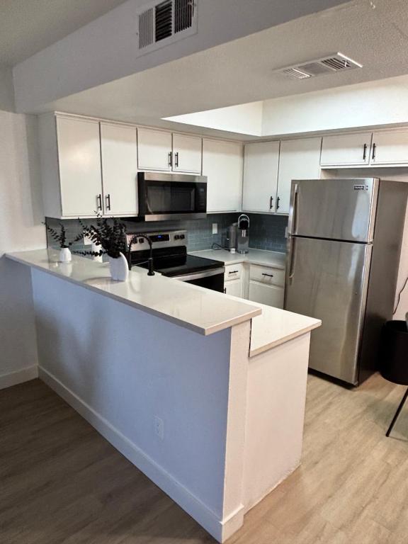 a kitchen with white cabinets and stainless steel appliances at Mesa 1bedroom king size near Tempe & parks in Mesa