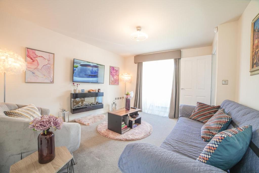 a living room with a blue couch and a tv at Town house Anfield stadium in Liverpool