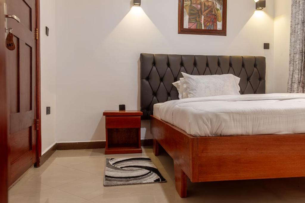 a bedroom with a bed with a black headboard at Namayani Safari Lodge in Arusha
