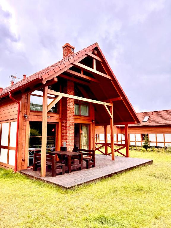 a house with a picnic table on a deck at Kaszubski Dom Ostoja Bukowo in Borowy Młyn