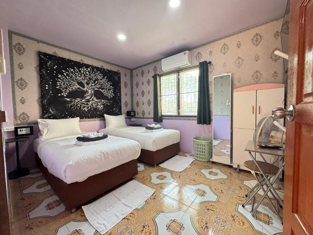 a bedroom with two beds and a painting on the wall at Serenity House 4B in Nathon Bay