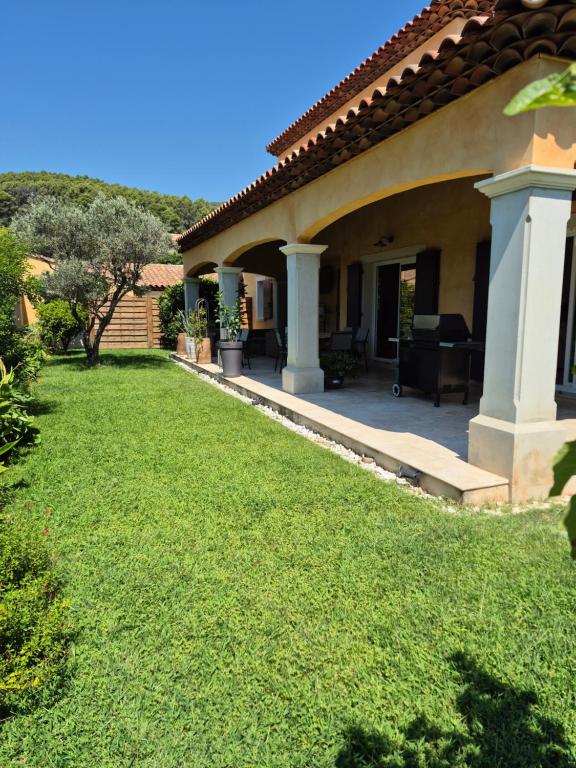 une maison avec une pelouse devant dans l'établissement Villa au pied d'une colline, à La Farlède
