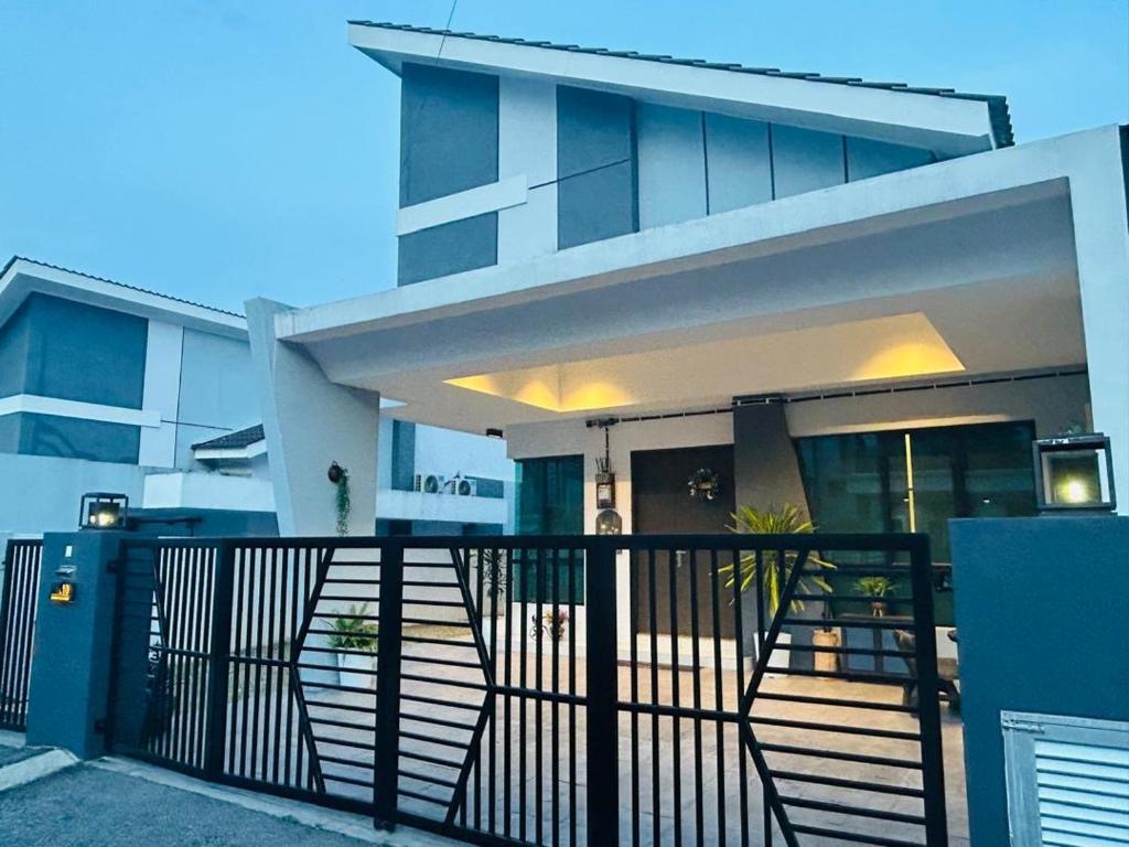a house with a black fence in front of it at Ethereal Ipoh Homestay in Ipoh