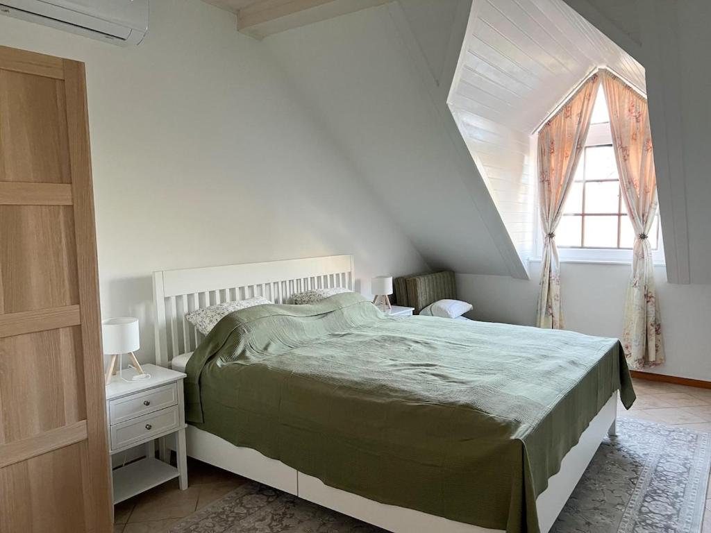 a white bedroom with a bed and a window at Apartment house Hévíz in Hévíz