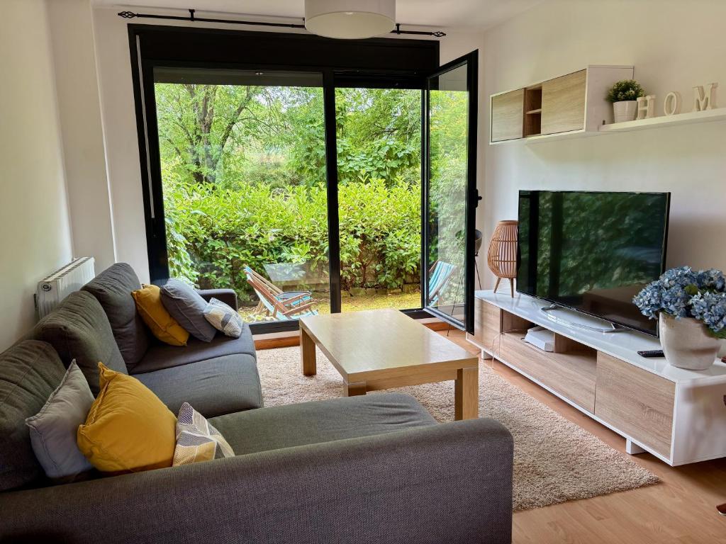 a living room with two couches and a flat screen tv at AIzaetxea in Jaca