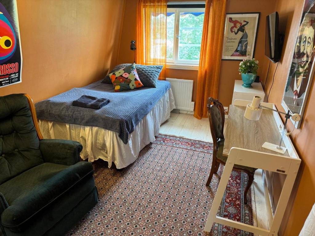 a small bedroom with a bed and a chair at Cozy Room in Uppsala