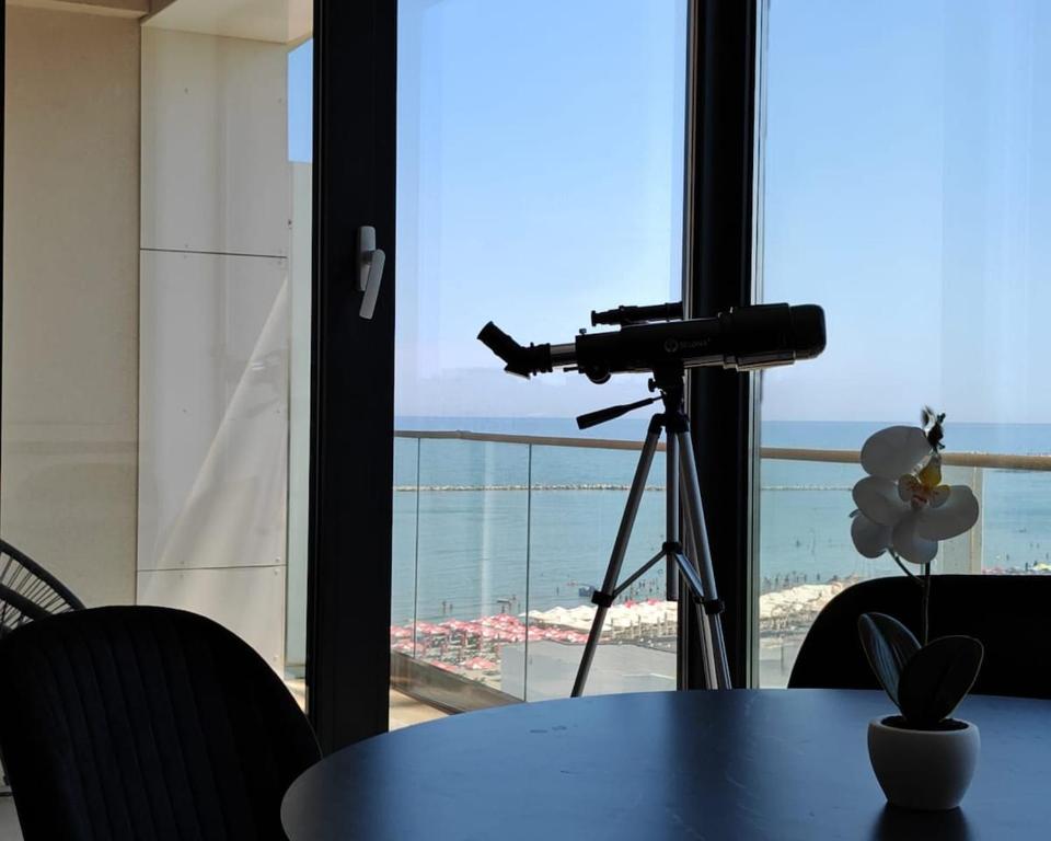 a camera on a tripod next to a table with a view of the ocean at Onix Studio Infinity 801 in Văleni