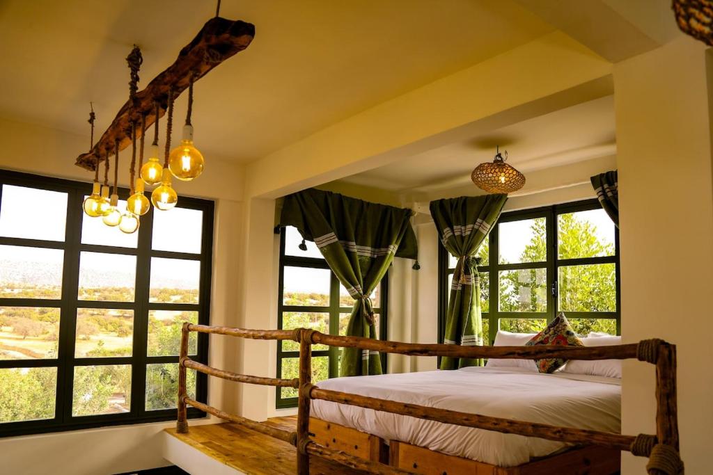 a bedroom with a bed in a room with windows at Farmhouse Loft Apartment at Mogador Essaouira 