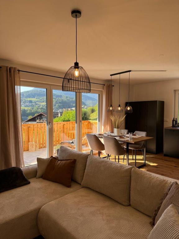 a living room with a couch and a dining room table at Neubau, Bergpanorama, gute Lage, Tiefgarage in Berchtesgaden