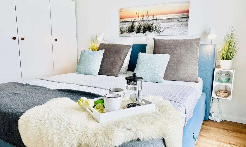 a bedroom with two beds with a tray on it at Surfbude, Olpenitz - moderne Ferienwohnung in direkter Strandnähe mit eigenem Eingang, Sauna, Kaminofen, Balkonterrasse und Parkplatz in Kappeln