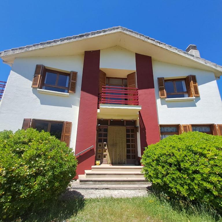 a white and red house with stairs and bushes at Ezemil Etxea in Lumbier