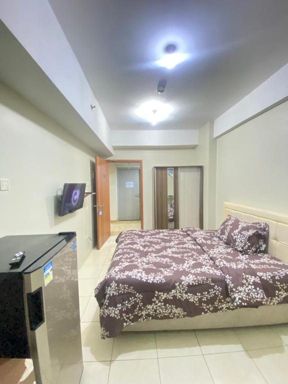 una camera da letto con un letto e una scrivania di Apartment greenlake view by lens room a Pondokcabe Hilir