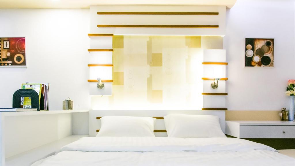 a hotel room with a bed and a mirror at Sunset Residence Pinklao in Bangkok