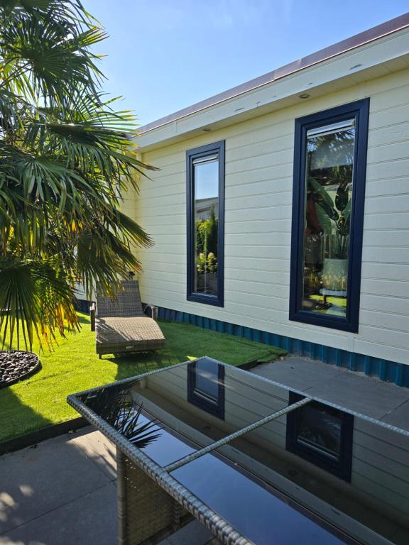 a house with a glass table in a yard at Chalet Dune chaletpark krabbenkreek Sint Annaland in Sint Annaland