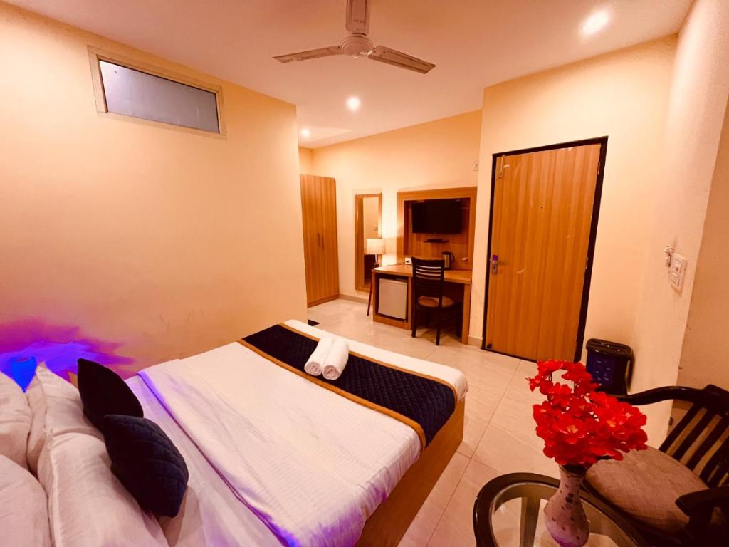 a bedroom with a bed and a table with flowers at The Aqua Lodge, A budget friendly hotel - Haridwar in Haridwār