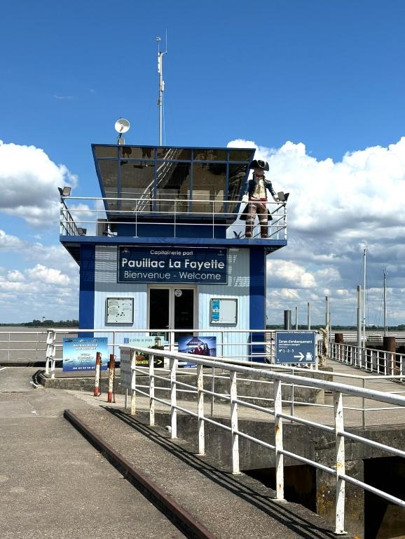 two people standing on a pier with a ferry at La Belle Escale in Pauillac