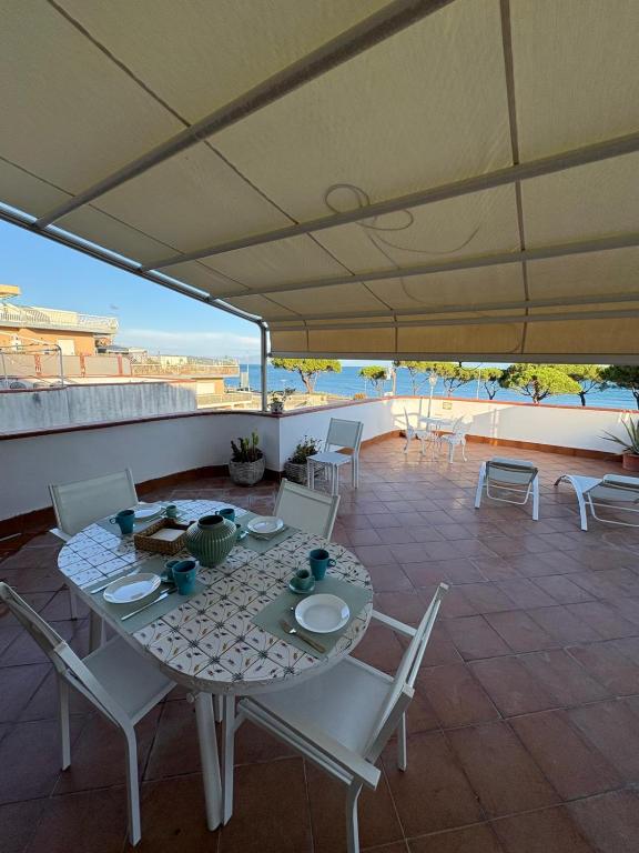 a table and chairs on a patio with an umbrella at Una Rotonda sul Mare in Formia