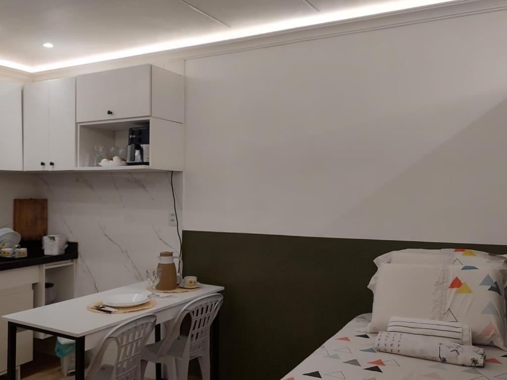 a small kitchen with a bed and a small table at Studio 102 Cop 30 in Curro Velho