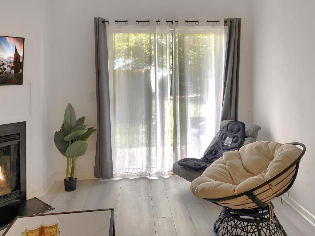 ein Wohnzimmer mit einem Stuhl und einem großen Fenster in der Unterkunft UNCW-Wrightsville Beach-Private Apartment in Wilmington