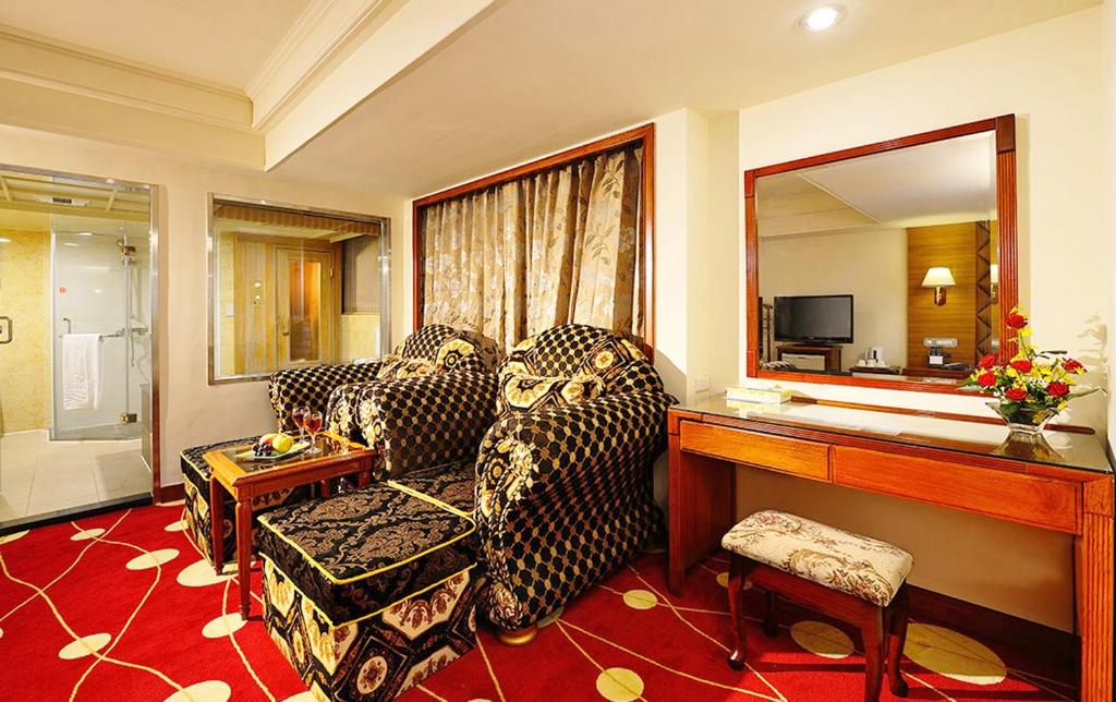 a living room with two couches and a mirror at Chyuan Du Spring Resort in Taipei