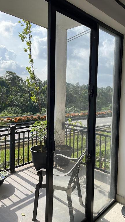 a glass door that is open to a balcony at Highway View Transit Kiribathgoda in Kiribathgoda