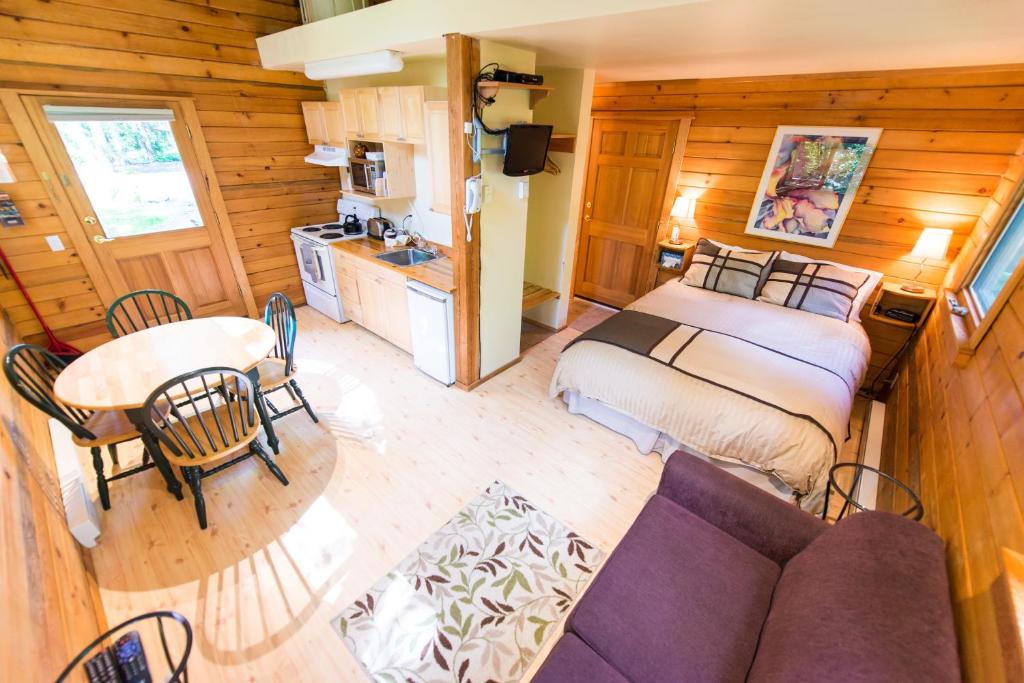 Habitación con cama, sofá y mesa. en Across the Creek Cabins, en Clearwater