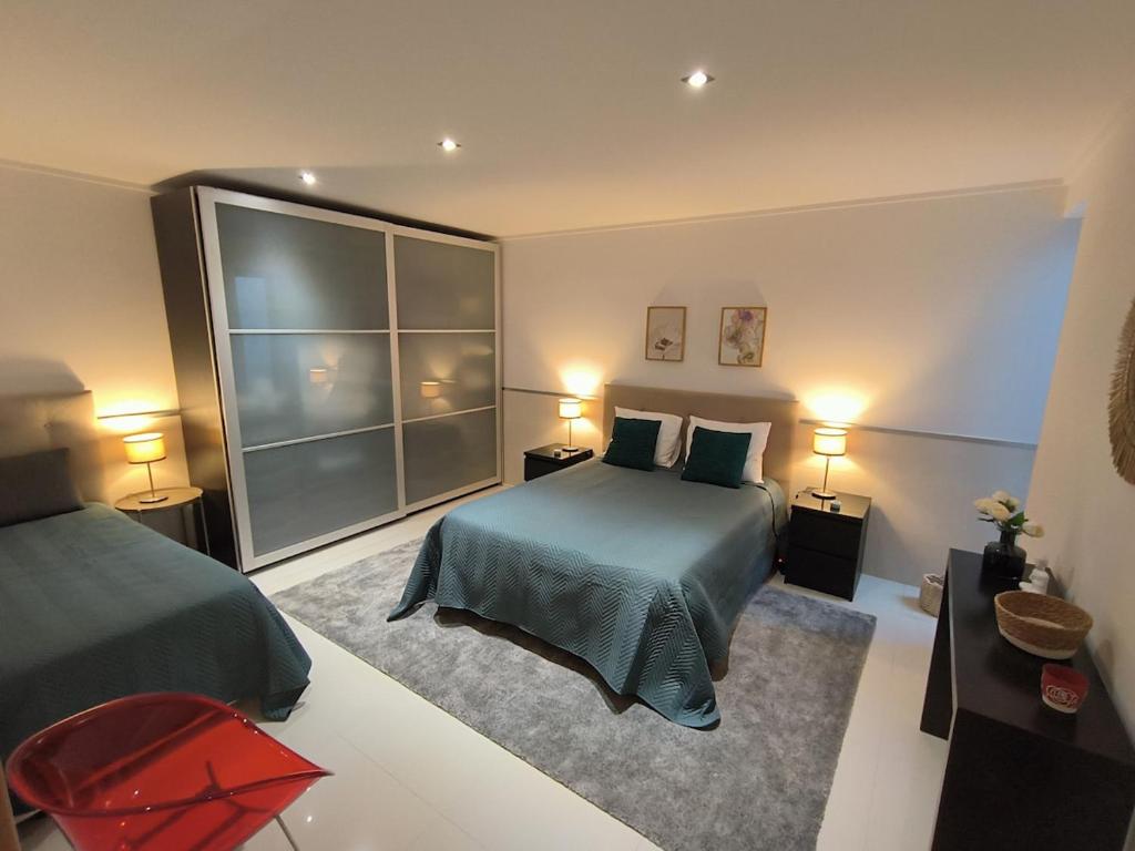 a bedroom with two beds and two tables and two lamps at Apartamento "Vila Serena Marisol" in Corroios
