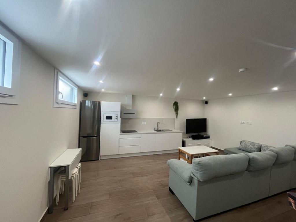 a living room with a couch and a kitchen at Loft Puerto Real in Puerto Real