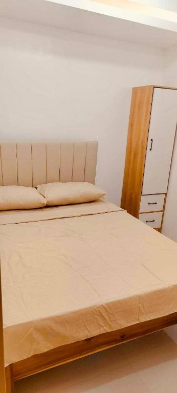 ein Schlafzimmer mit einem Bett mit hölzernem Kopfteil in der Unterkunft Svens Place in Puerto Princesa